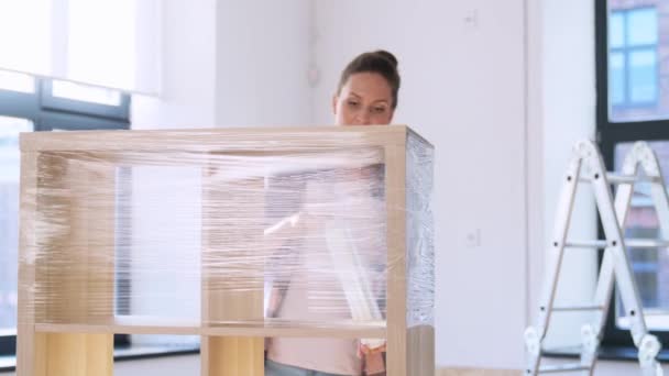 Vrouw verpakking plank met plastic wrap thuis — Stockvideo