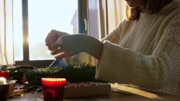 Женщина делает еловый рождественский венок дома — стоковое видео