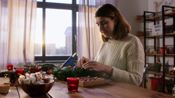 家庭でモミのクリスマスリースを作る幸せな女性 — ストック動画