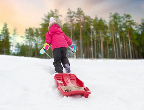 Meisje met sleeën op sneeuw heuvel in de winter — Stockfoto