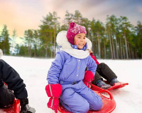 Маленька дівчинка на санчатах на сніговій тарілці взимку — стокове фото