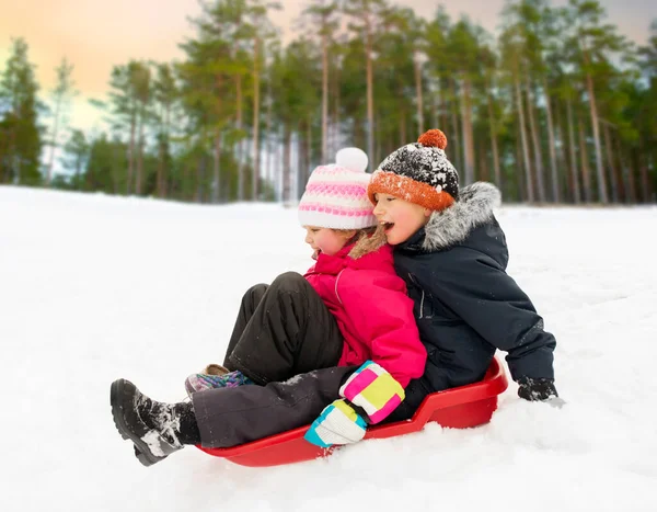 Kleine kinderen glijden op slee bergafwaarts in de winter — Stockfoto