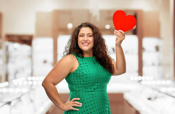 Mulher feliz em vestido verde segurando coração vermelho — Fotografia de Stock