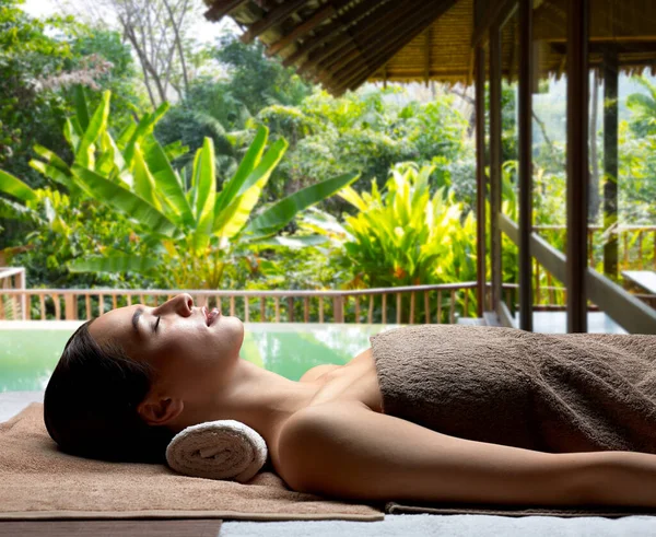 Ung kvinna ligger på spa över exotiska resort — Stockfoto