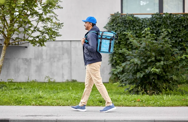 Happy delivery man with bag walking in city — Stock Photo, Image