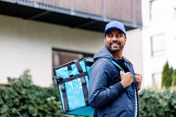 Happy smiling indian delivery man with bag in city — Stock Photo, Image