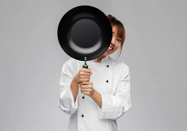 Femme chef regardant dehors par derrière poêle à frire — Photo