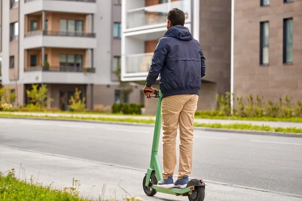 Hombre montando scooter eléctrico en la ciudad —  Fotos de Stock