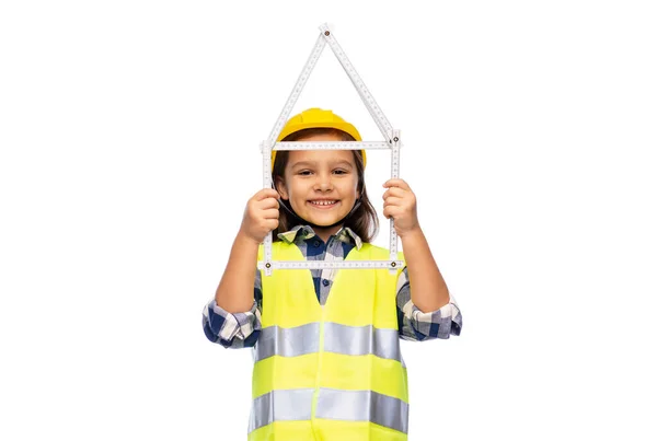 Маленька дівчинка в шоломі з лінійкою у формі будинку — стокове фото