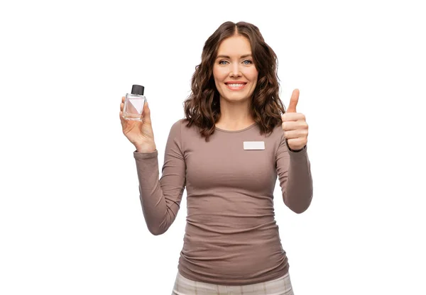 Female shop assistant with perfume shows thumbs up — Stock Photo, Image