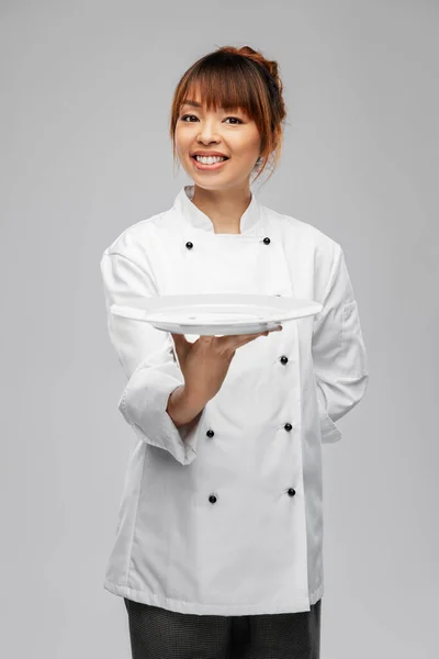 Feliz mujer sonriente chef sosteniendo plato vacío —  Fotos de Stock