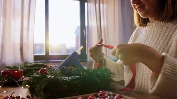 Щаслива жінка робить яскравий різдвяний вінок вдома — стокове відео