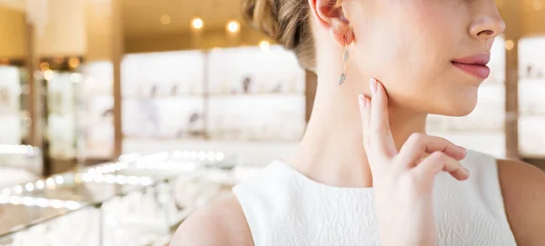 Femme avec boucle d'oreille en diamant à la bijouterie — Photo