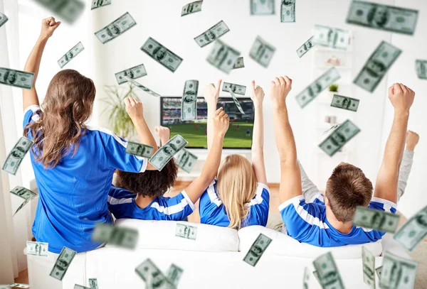 お金の雨の上にテレビを見て幸せなサッカーファン — ストック写真