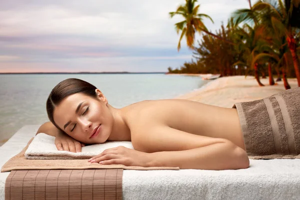 Young woman lying at spa over exotic beach — Stock Photo, Image