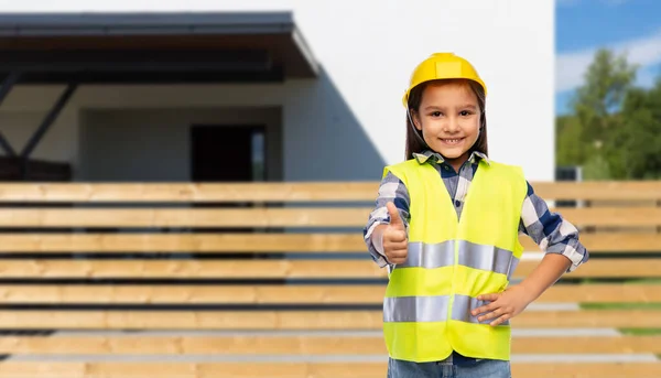 Girl in helmet and safety vest shows thumbs up — Stock Photo, Image