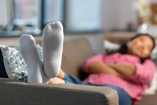 Primer plano de pies de mujer durmiendo en sofá en casa —  Fotos de Stock