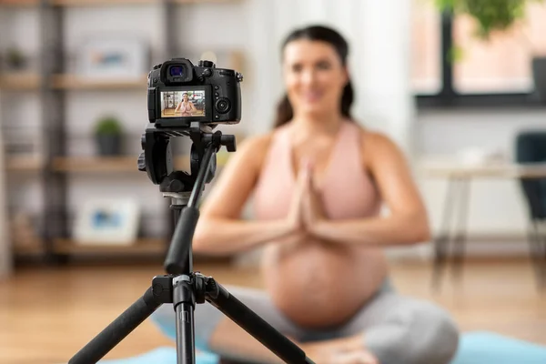 Mujer embarazada o bloguera de yoga con cámara en casa —  Fotos de Stock