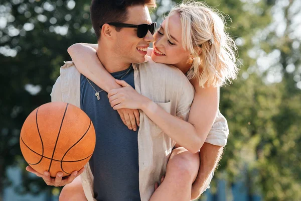 Couple heureux s'amuser sur terrain de jeu de basket — Photo