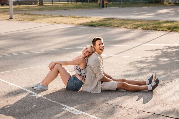Basketbol sahasında oturan mutlu çift — Stok fotoğraf