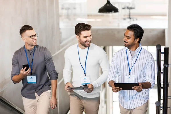 Mannen met conference badges die naar boven lopen — Stockfoto