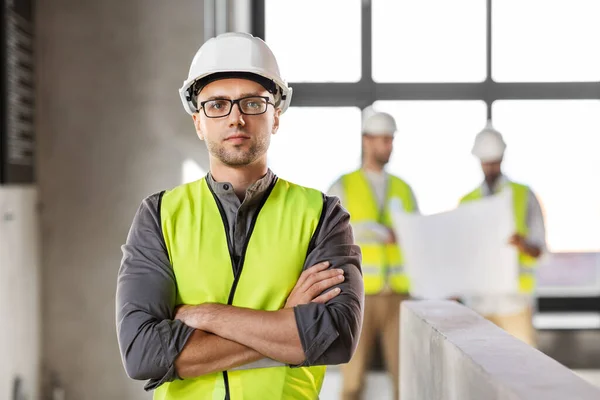 Arquiteto masculino em capacete e segurança oeste no escritório — Fotografia de Stock