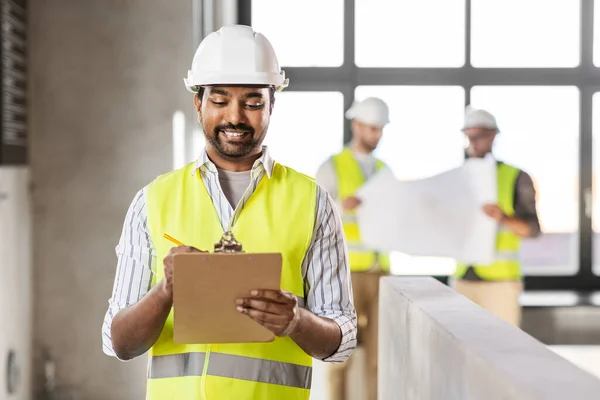 Architekt mit Helm und Klemmbrett im Büro — Stockfoto