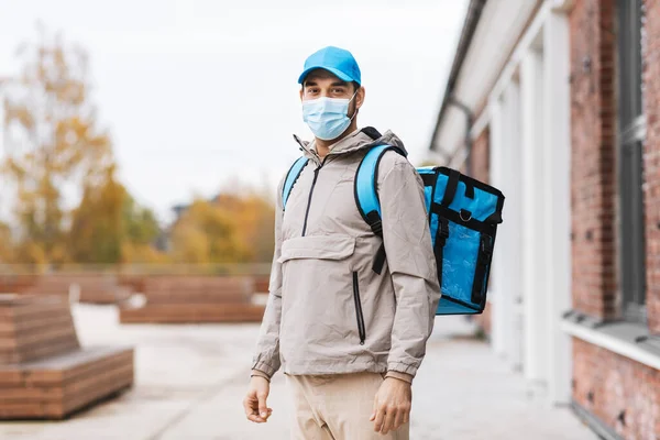 Leverans man i mask med termisk väska i staden — Stockfoto