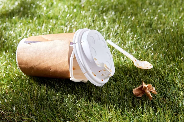 Close up of used disposable coffee cup on grass — Stock Photo, Image