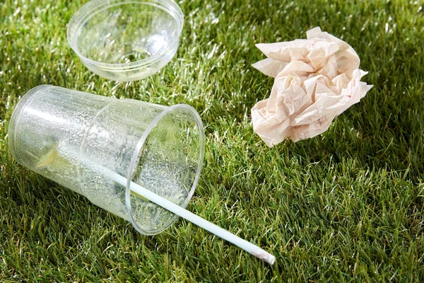 Çimlerin üzerinde kullanılmış plastik bardağı kapat. — Stok fotoğraf