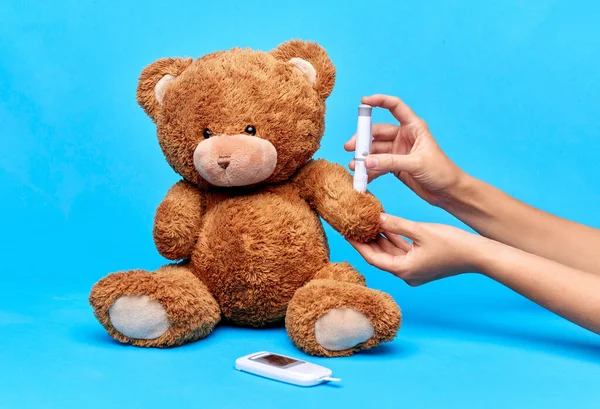 Руки делает инсулин инъекции плюшевого медведя — стоковое фото