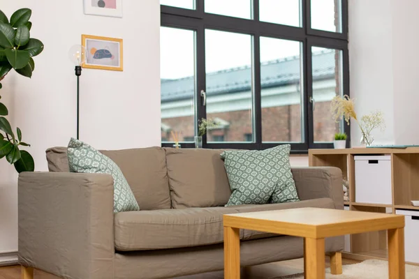 Sofá com almofadas na acolhedora sala de estar em casa — Fotografia de Stock
