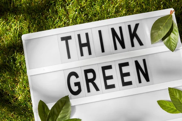 Light box with think green words on grass — Stock Photo, Image