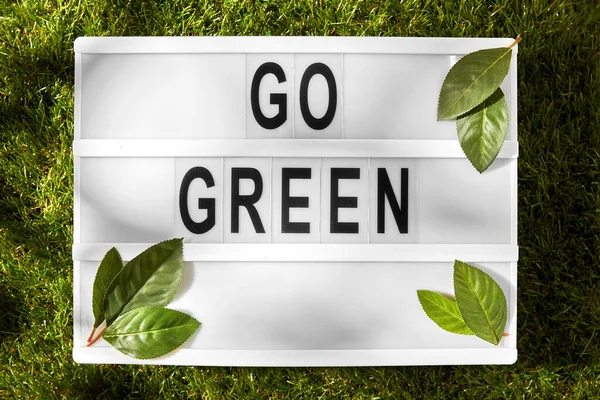 Светлая коробка с зелеными словами на траве — стоковое фото