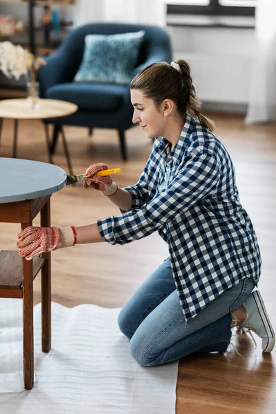 Mulher pintando mesa de madeira velha com cor cinza — Fotografia de Stock