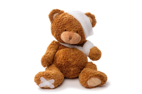 Teddy bear toy with bandaged head and paw — Stock Photo, Image