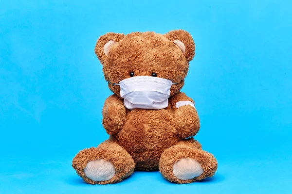 Medvídek v lékařské masce s náplastí na tlapce — Stock fotografie