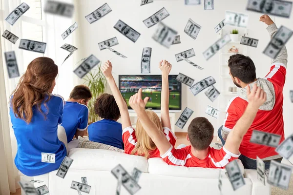 Glad fotboll fans tittar på tv över pengar regn — Stockfoto