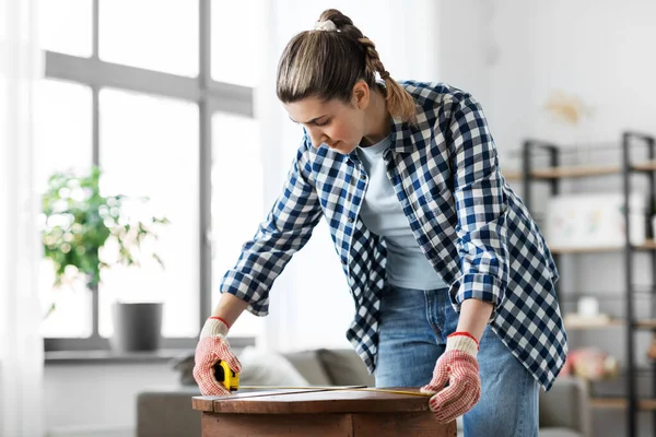 Woman with ruler measuring table for renovation — Stock Photo, Image