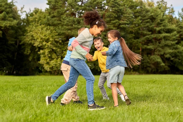 Crianças felizes brincando e se divertindo no parque — Fotografia de Stock