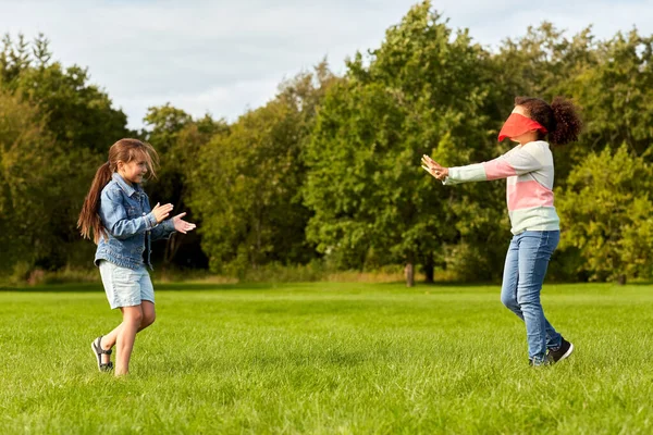 Счастливые девочки, играющие и бегающие в парке — стоковое фото