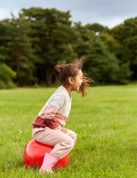公園でホッパーボールの上で跳ねる幸せな女の子 — ストック写真