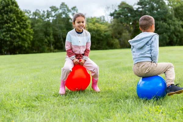Niños felices rebotando en las bolas de la tolva en el parque —  Fotos de Stock
