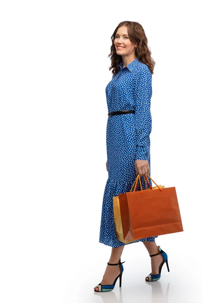 Mujer feliz en vestido caminando con bolsas de compras —  Fotos de Stock