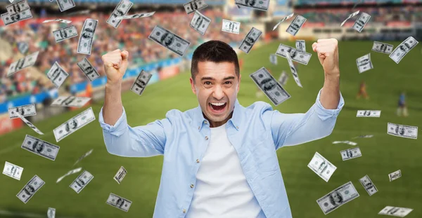 Happy man with over money rain on football field — Stock Photo, Image