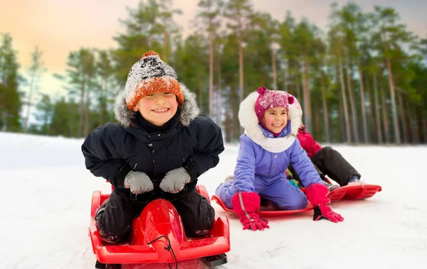 Gelukkig weinig kinderen glijden omlaag op sleeën in de winter — Stockfoto