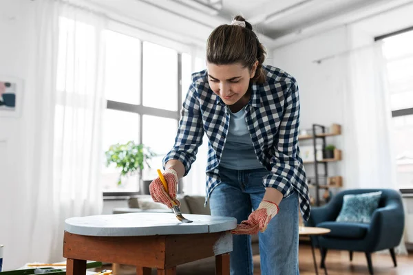Woman painting old wooden table with grey color — Stock Photo, Image