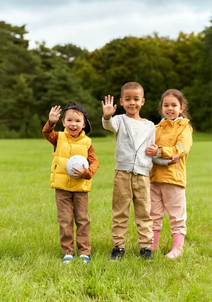Щасливі діти з футбольним м'ячем у парку — стокове фото