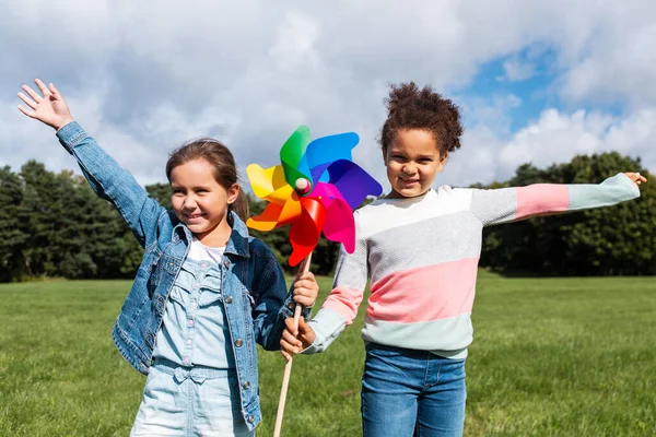 Meninas felizes com pinwheel se divertindo no parque — Fotografia de Stock