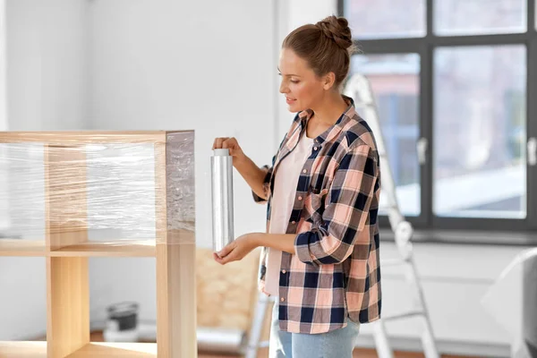 Gelukkig vrouw verpakking plank en verhuizen naar nieuw huis — Stockfoto
